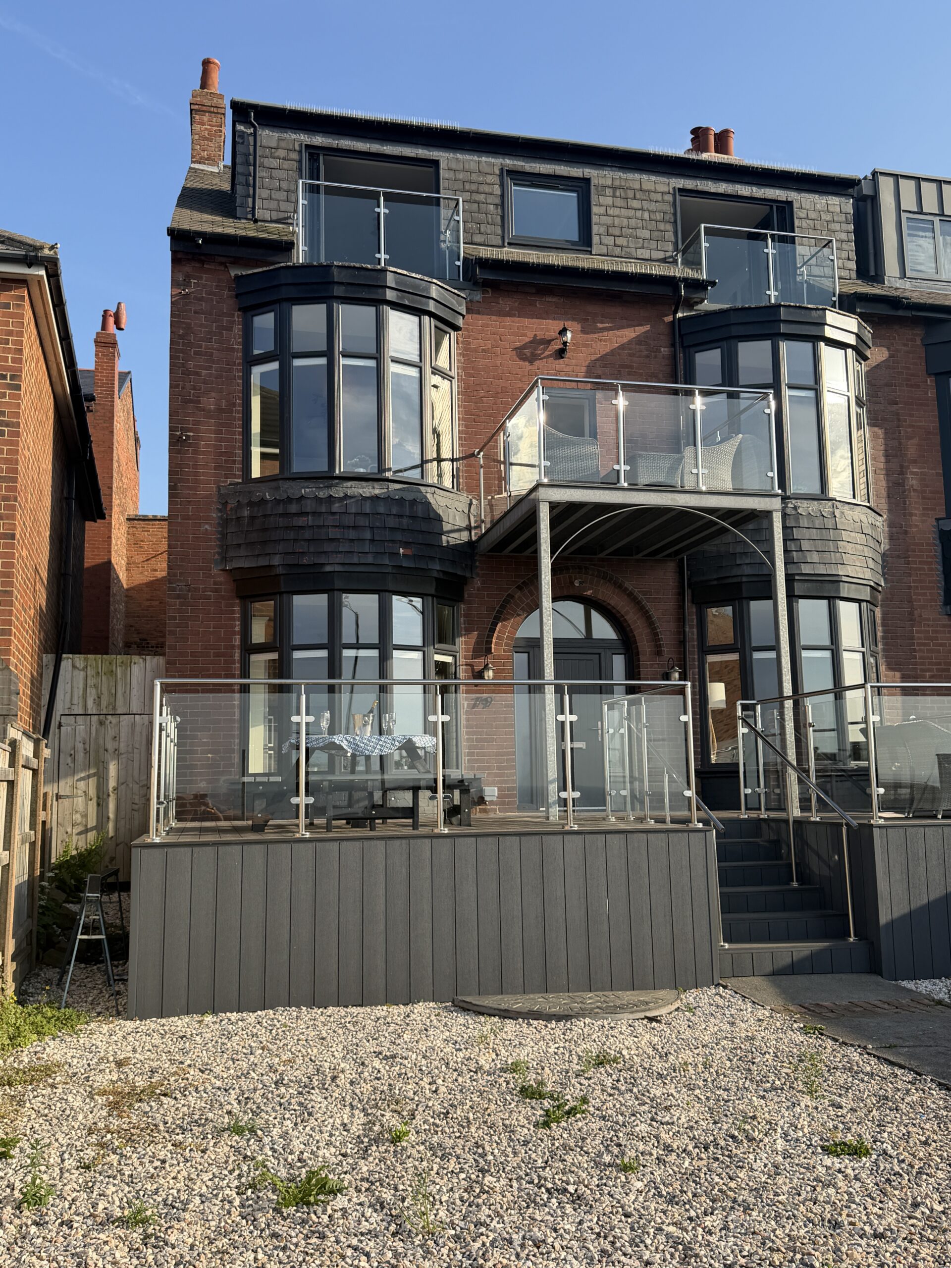 Modern brick exterior with glass balconies and spacious outdoor area